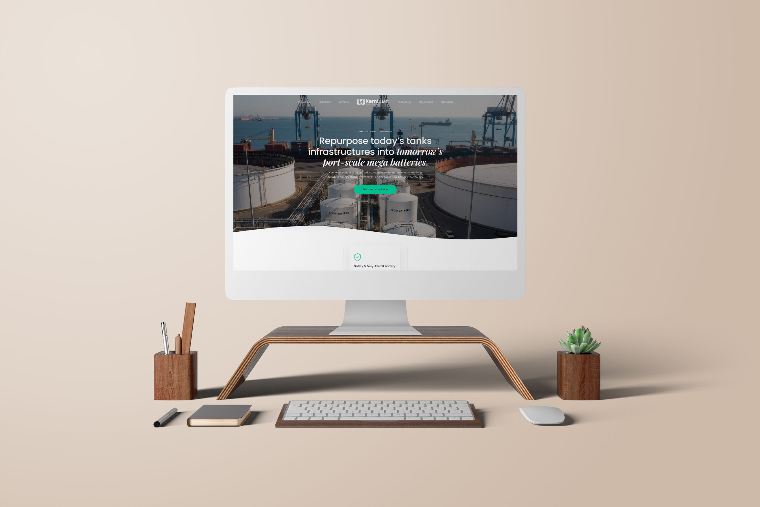 Un bureau informatique moderne avec un écran affichant un site web consacré aux infrastructures de réservoirs, entouré de fournitures de bureau, d'un clavier, d'une souris, d'un bloc-notes, d'un stylo et de deux petites plantes en pot, le tout sur un fond beige.