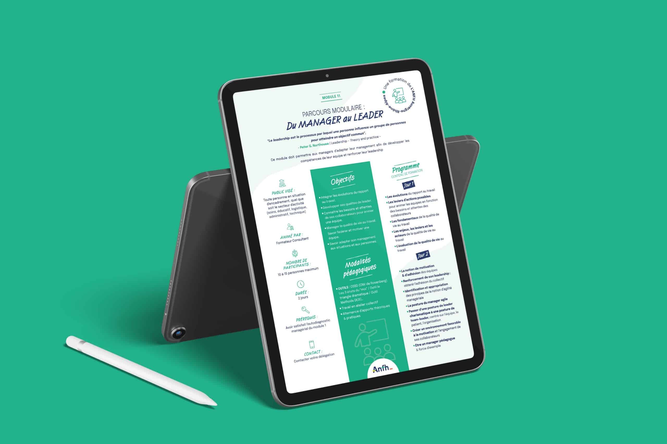Une tablette avec un stylet repose sur une surface verte, affichant un document en français intitulé "Du Manager au Leader", comportant des icônes, des colonnes de texte, des accents turquoise, et faisant référence au Catalogue formations ANFH. Le texte est clair mais pas entièrement lisible.